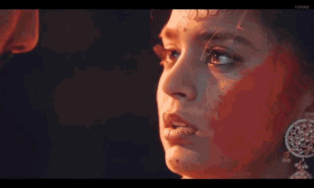 a woman with red paint on her face is looking at a man