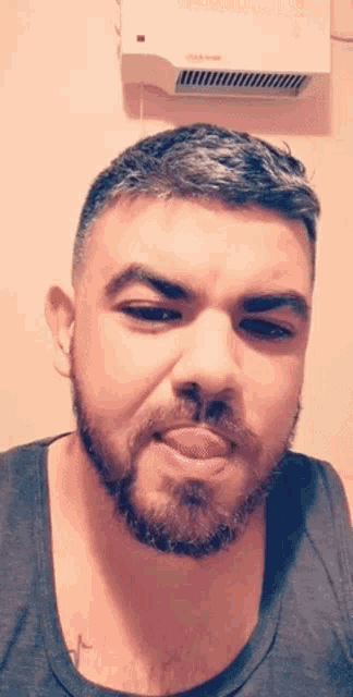 a man with a beard is making a funny face