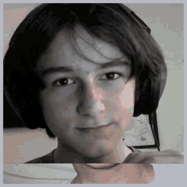 a young man wearing headphones is looking at the camera