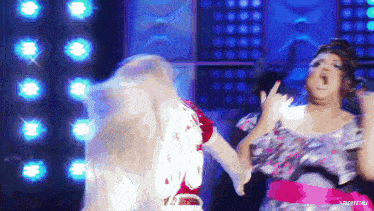 two women are dancing on a stage and one of them is wearing a pink belt that says ' j.f. crystal '