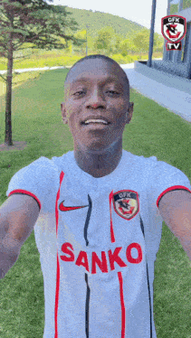 a man wearing a white shirt with the word sanko on the front