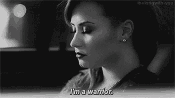 a black and white photo of a woman with the words `` i 'm a warrior '' written on her face .