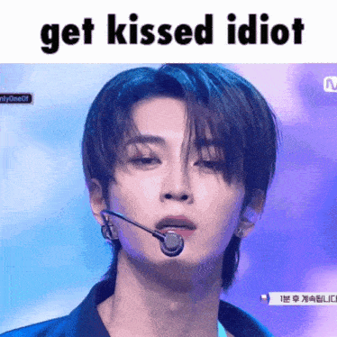 a man with a microphone in his mouth and the words get kissed idiot