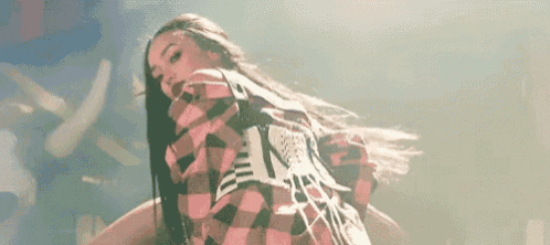 a woman wearing a plaid shirt is dancing on a stage .