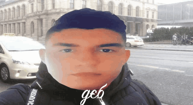 a man is taking a selfie with a taxi in the background and the word geb is on the bottom of his face