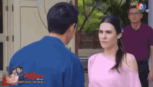 a man and a woman are looking at each other while a man stands behind them .
