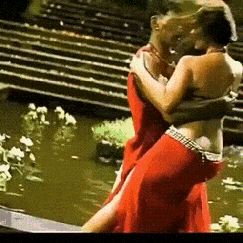 a man in a red dress is holding a woman in a red dress