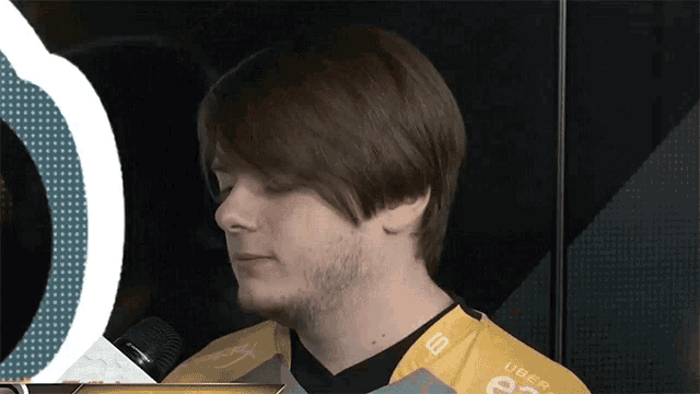 a man with a beard wearing a yellow shirt that says uber on it