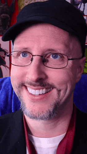 a man with glasses and a beard smiles for the camera