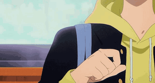 a person wearing a yellow hoodie and a black jacket is holding a backpack .