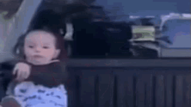 a baby is sitting in the back seat of a car with a blurred background .