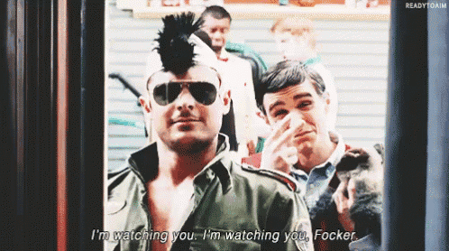a man with a mohawk and sunglasses says " i 'm watching you "