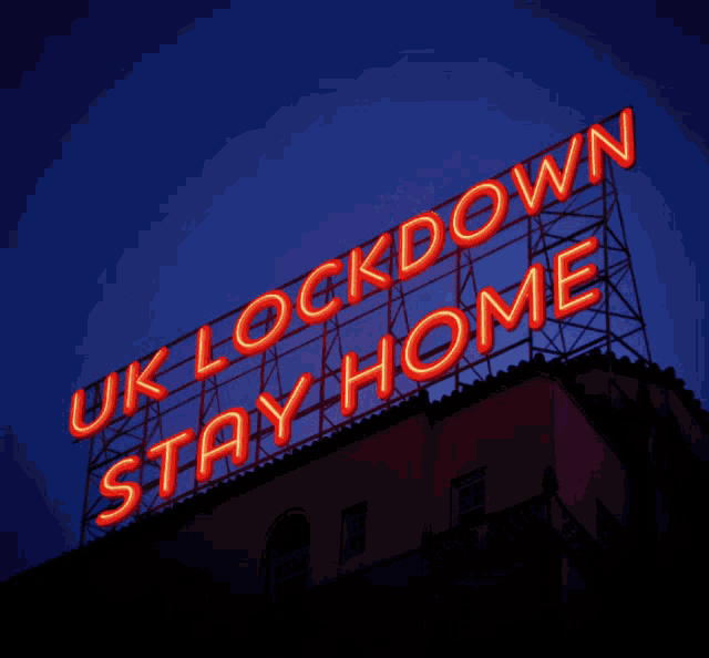 a neon sign on top of a building that says uk lock down stay home