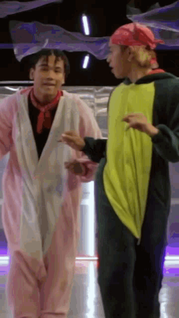 a couple of men are standing next to each other in costumes .