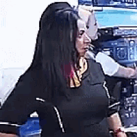a woman in a black shirt is standing in front of a man .