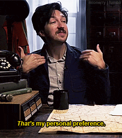 a man sitting at a desk with a mug and a phone and says that 's my personal preference