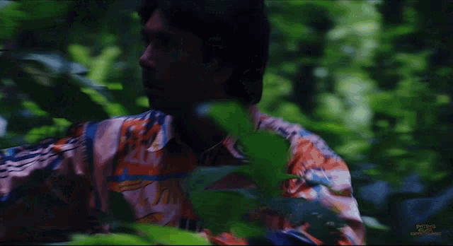 a man in a colorful shirt with the letter g on the front
