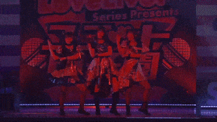 a girl with a microphone in her mouth is sitting on a stage .
