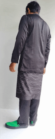 a man wearing a black shirt and black pants is standing in front of a white wall
