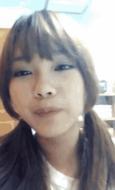 a close up of a girl 's face with a white shirt on