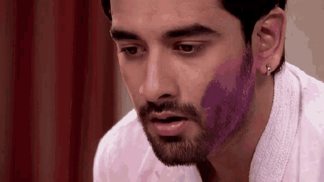a man with a beard is covered in purple powder .