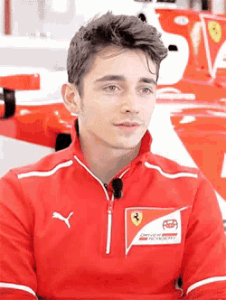 a young man is wearing a red jacket with a ferrari logo on it
