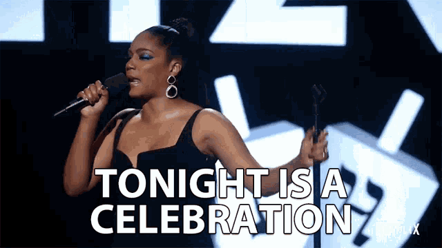 a woman singing into a microphone with the words " tonight is a celebration " behind her