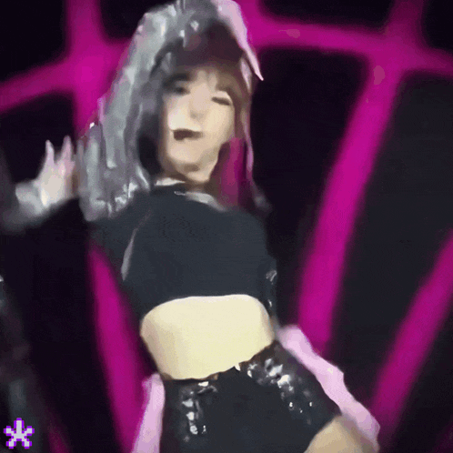 a woman in a crop top is dancing in front of a pink and black background