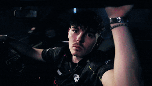 a man in a black shirt with a skull on it looks at the camera