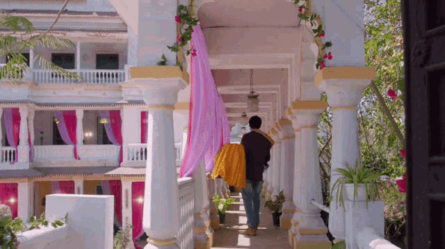 a man and a woman are walking down a hallway of a building