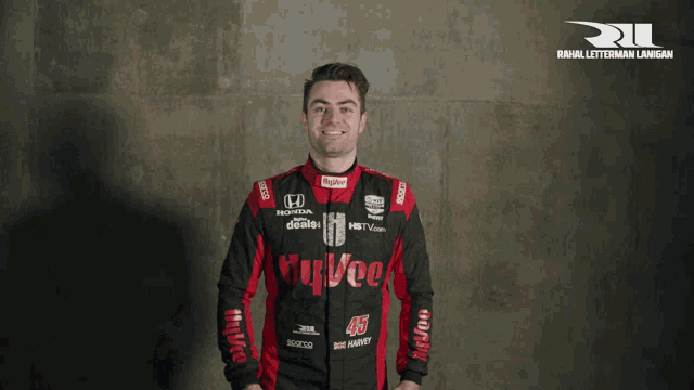 a man wearing a honda racing suit is clapping