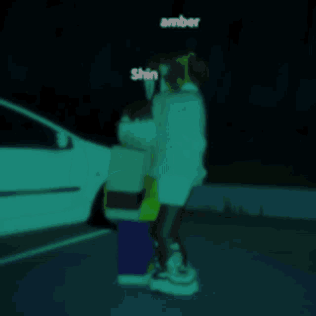 a person standing next to another person with amber written on the bottom right