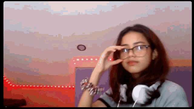 a girl wearing glasses and headphones is taking a picture of herself .