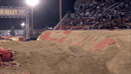 a dirt track with a sign that says r alley in the background