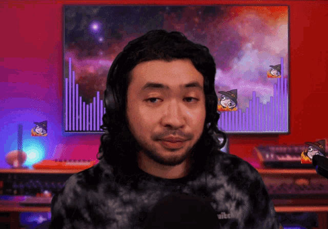 a man wearing headphones and a tie dye shirt that says twitch