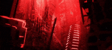 a city with a lot of buildings and a red light behind them