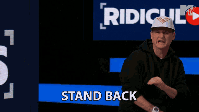 a man is dancing in front of a sign that says ridicul