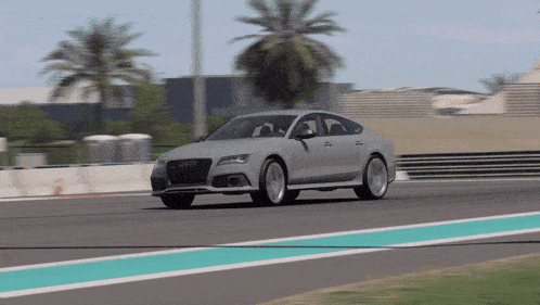 a silver audi rs7 is driving down a race track