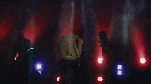 a group of people are dancing in a dark room