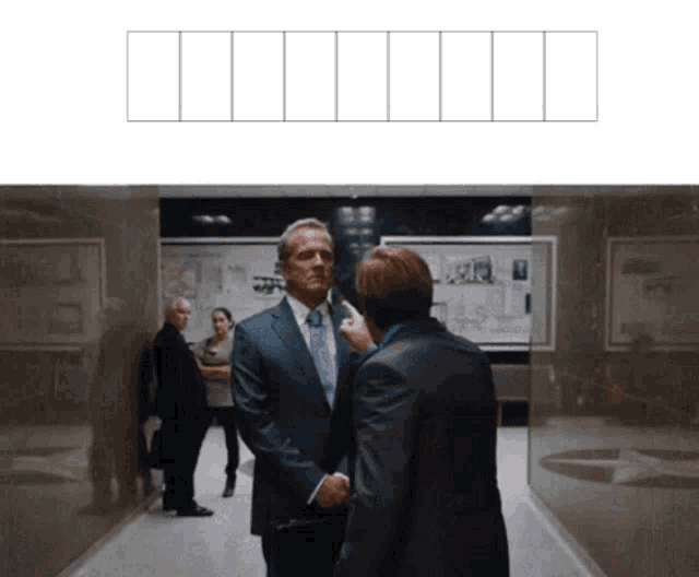 a man in a suit shakes hands with another man in a tie