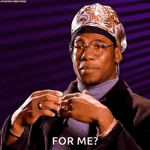 a man wearing glasses and a bandana is making a face and asking for me .