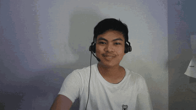 a man wearing headphones and a white shirt with a bear on it