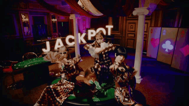 a group of women holding up a sign that says jackpot in a casino