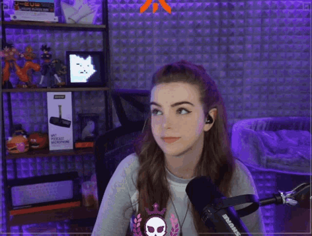 a woman is sitting in front of a microphone with a skull on her wrist