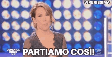 a woman stands in front of a screen that says partiamo cos !