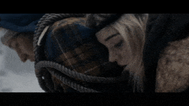 a man and a woman are wrapped in a blanket in the snow