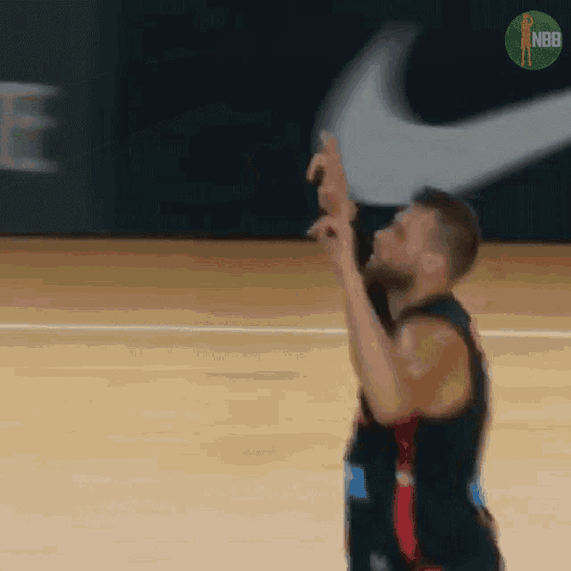 a basketball player throws the ball in the air with a nike logo in the background