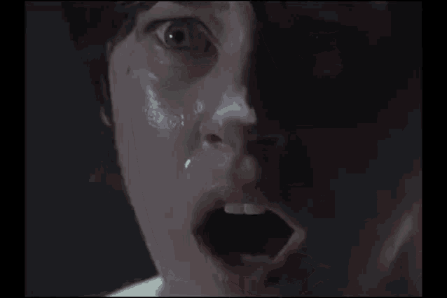 a close up of a woman 's face with a tear running down her face .