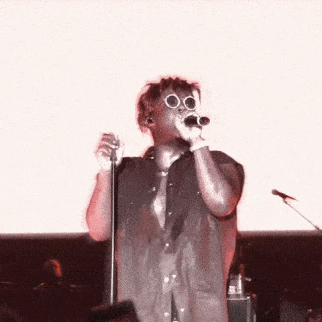 a man singing into a microphone wearing sunglasses