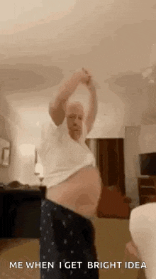 a man with a very large belly is dancing in a room .